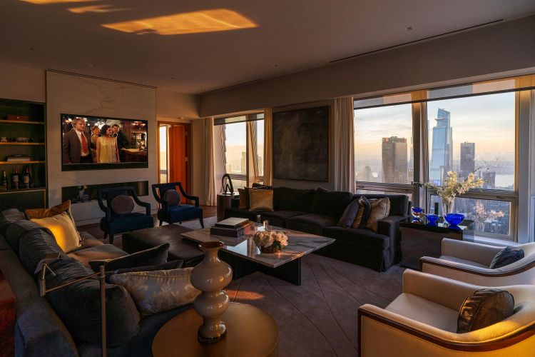 Luxury high-rise living room with panoramic view of city skyscrapers during golden hour