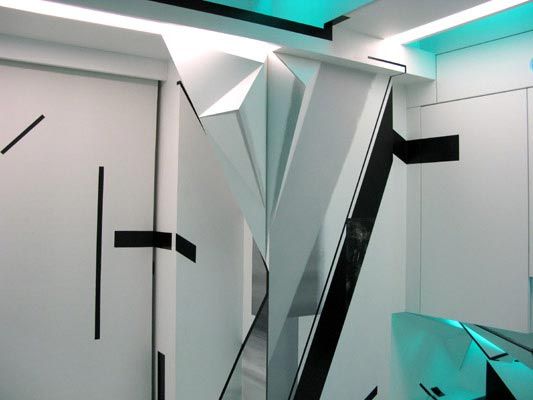 Futuristic interior wall with sharp origami-like folds, black line accents, and cyan light