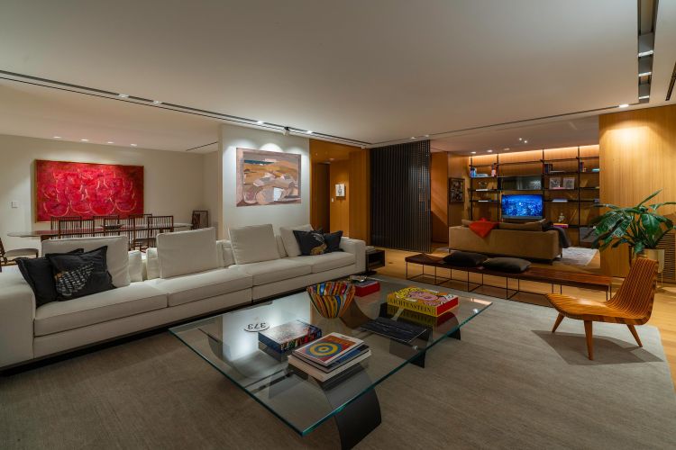 Spacious open-concept living and dining room at night with warm modern lighting